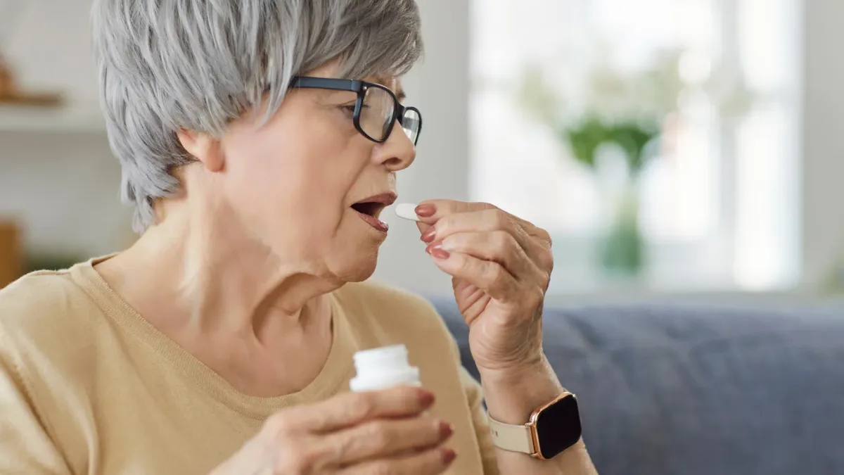 An older adult taking a supplement