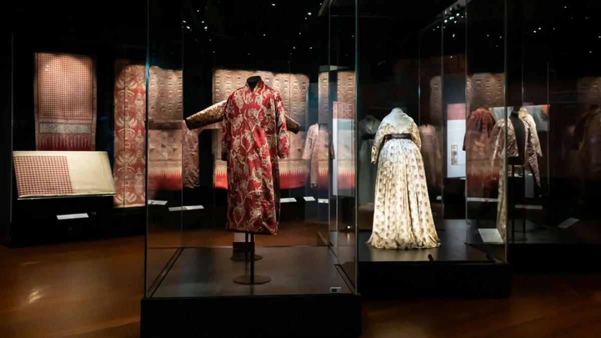 Traditional Peranakan garments and textiles on display in a museum gallery