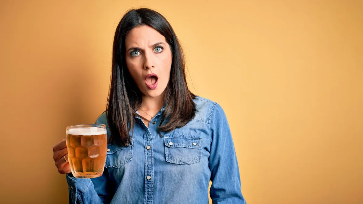 A person holding a glass of alcohol