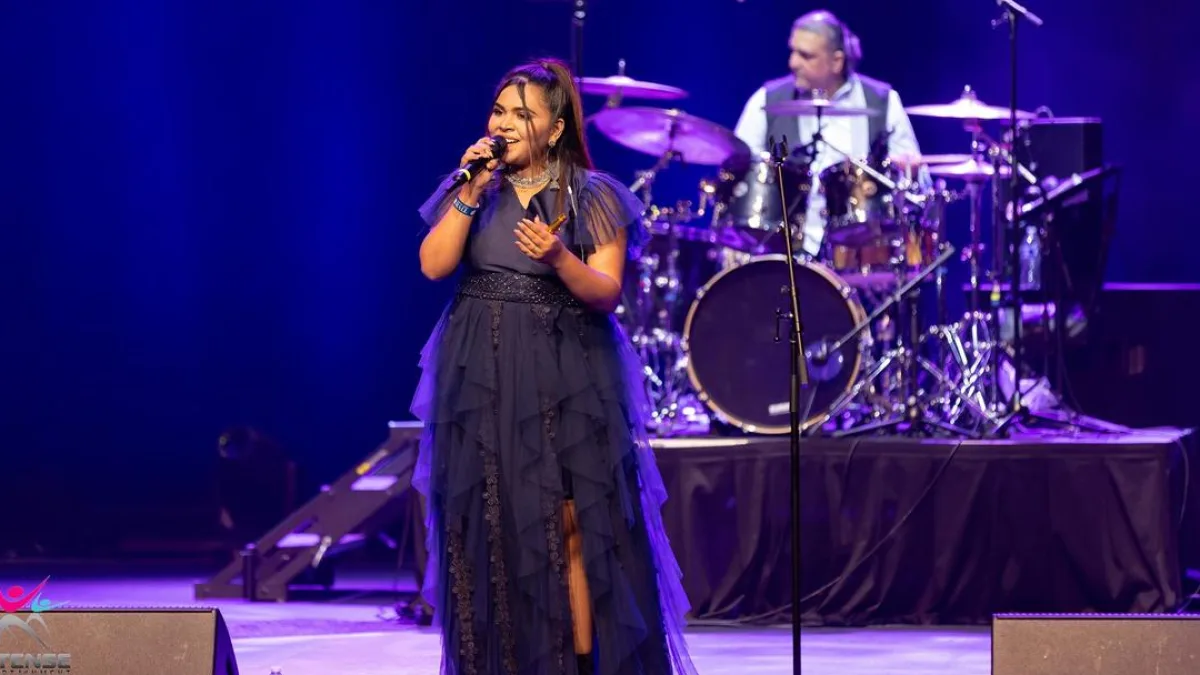 Singer performing on stage with a musical instrument