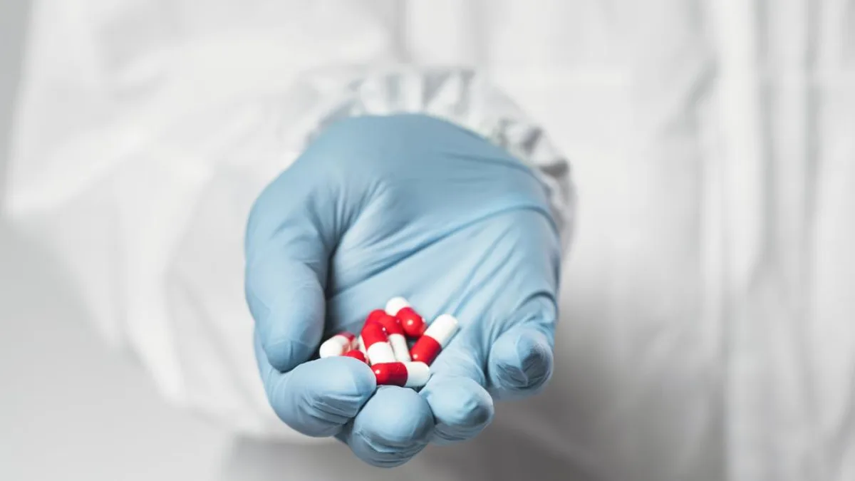 A person holding a packet of medicines