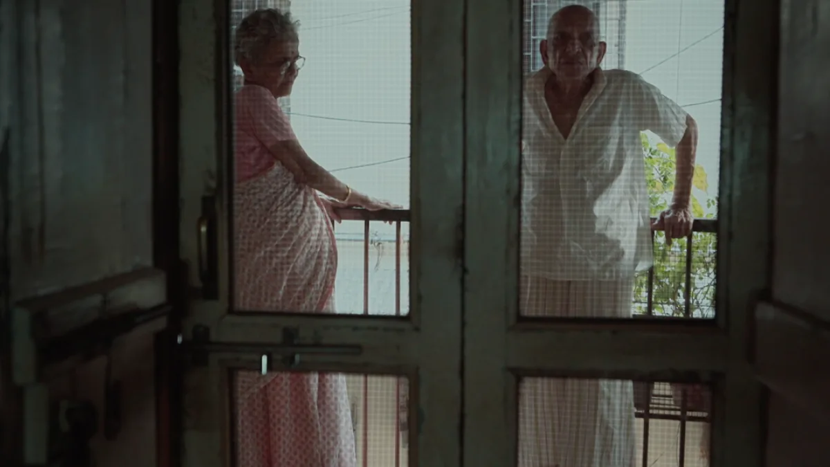 An elderly couple sitting together, looking at each other