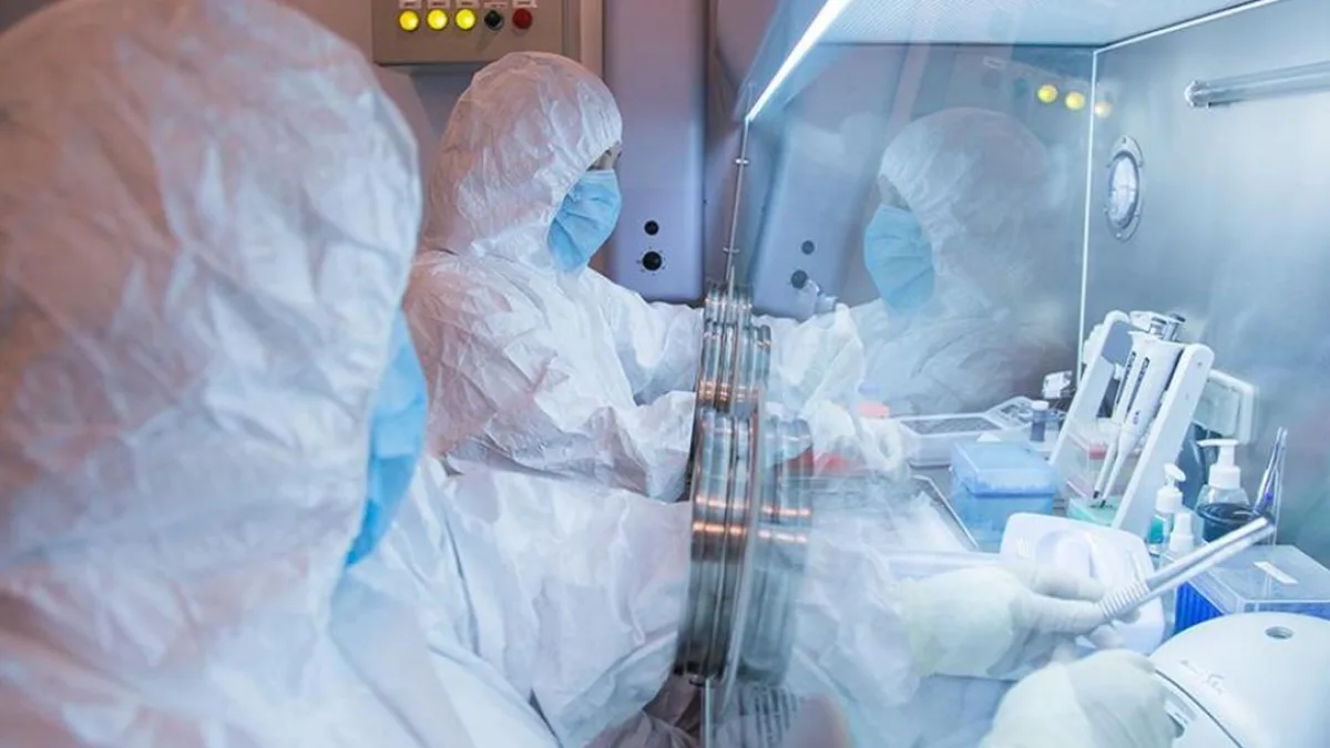 A scientist in a lab coat working with test tubes
