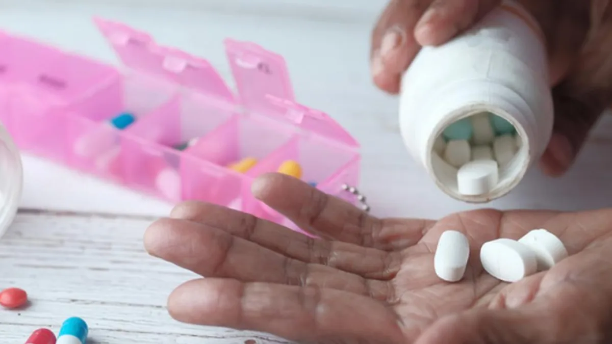 A person holding a packet of medicine